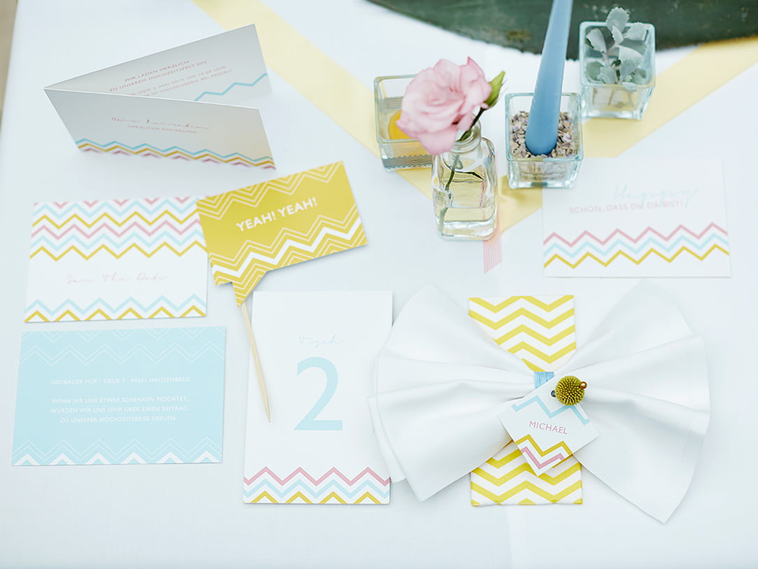 Kartendesign in Weiß, Gelb, Rosa, Blau auf einem Tisch mit und Kerzenständern